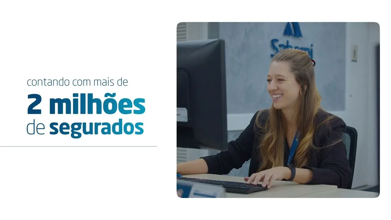 Cena do filme institucional da Sabemi: uma colaboradora sorrindo no computador, ao lado do texto contando com mais de 2 milhões de segurados.